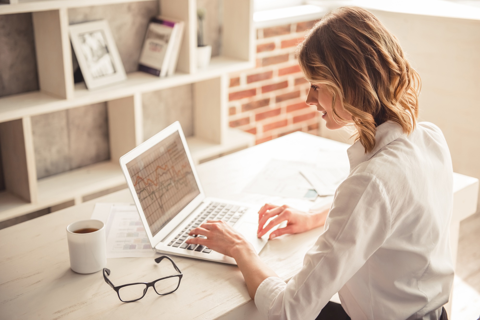 Woman Is Using A Laptop And Smiling While Working